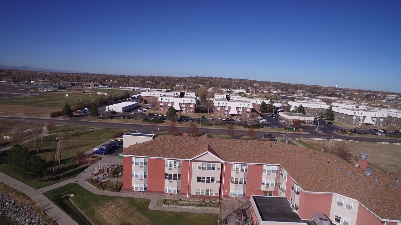 Aerial view of a pink multi-story building beside roads and open grass.