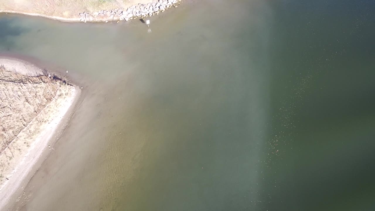 Aerial view at Hidden Lake, Colorado with a triangular sand point cutting into green water and no visible people.