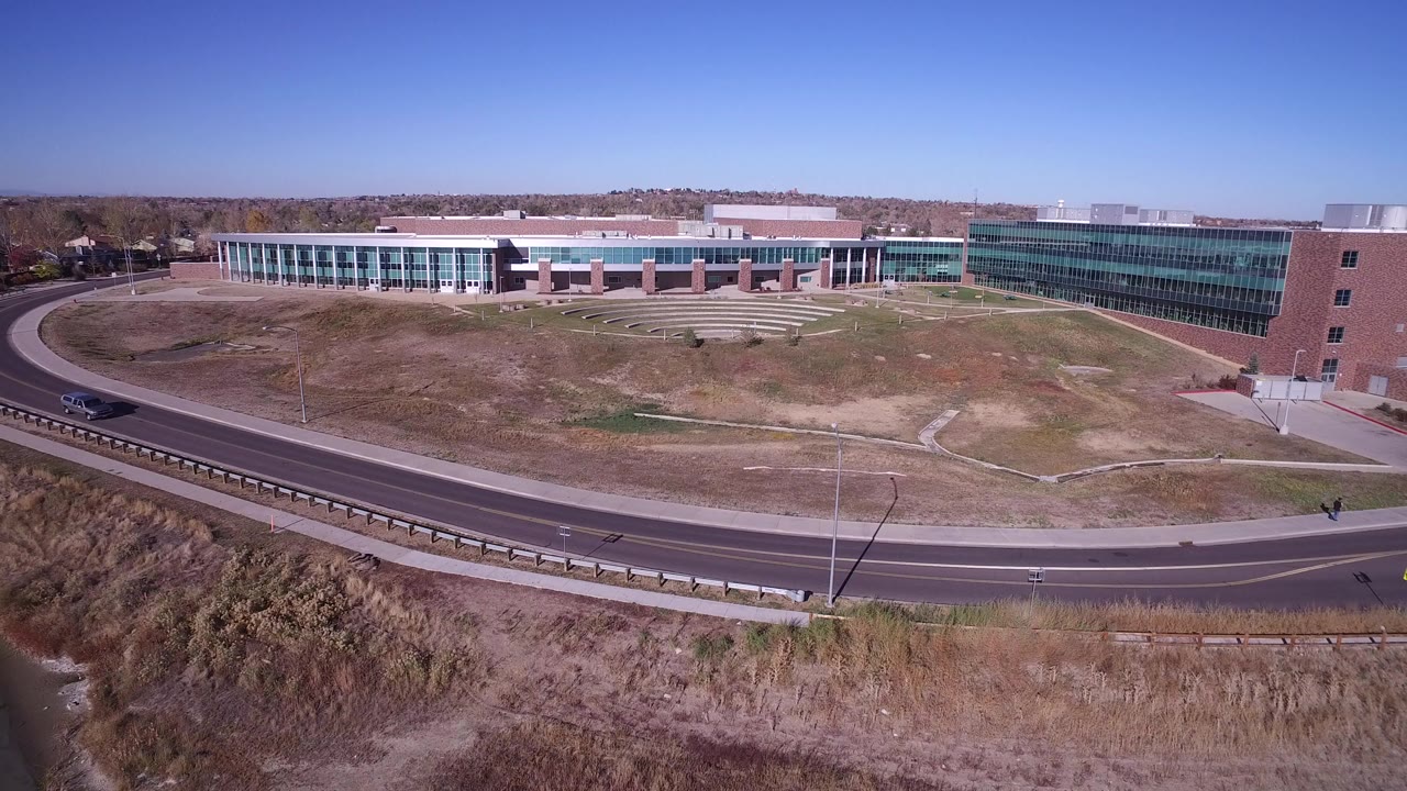 Wide aerial view of a modern building beside a curved road