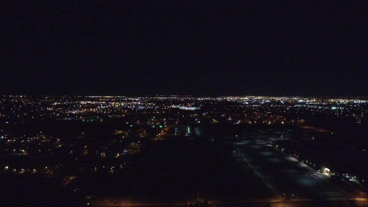 Dark aerial city lights under a black night sky.