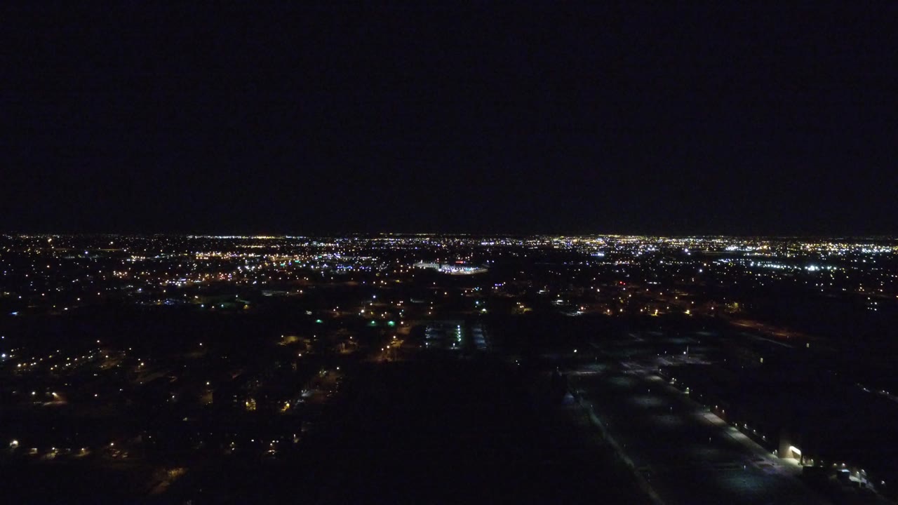 Wide night city lights under a dark sky