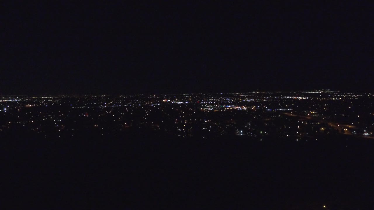 Night cityscape with scattered lights and dark foreground
