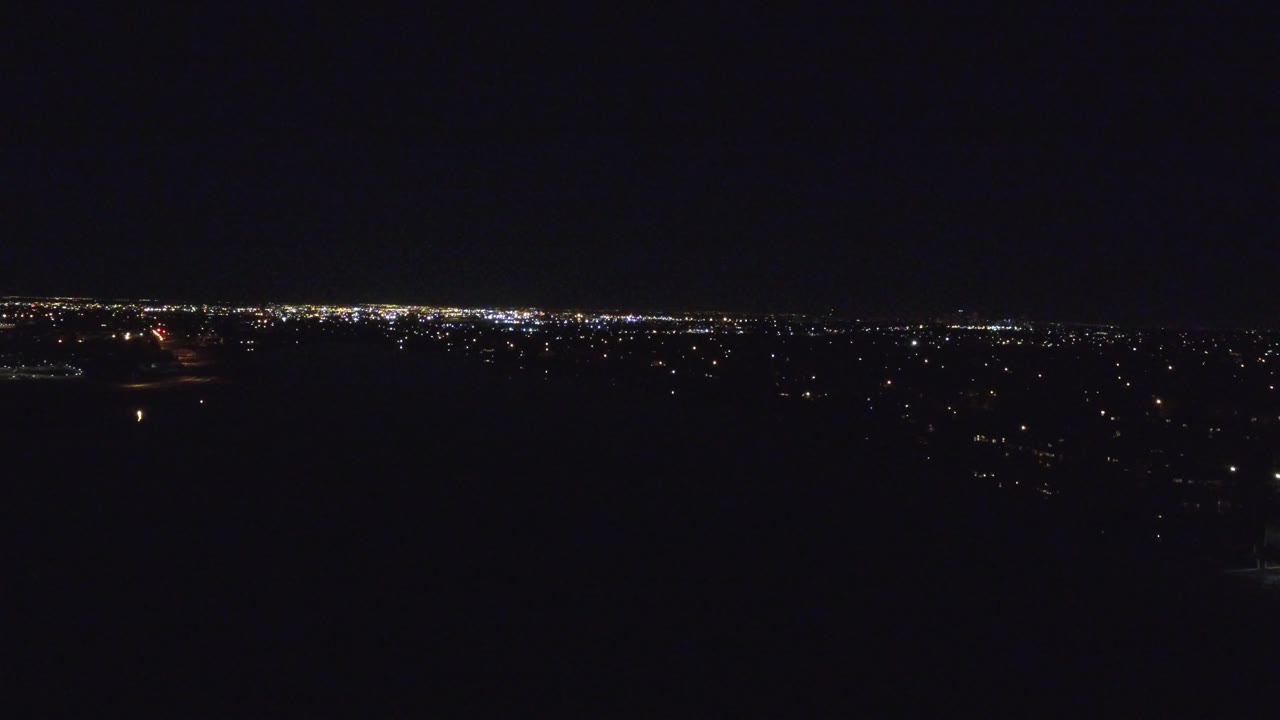 Distant illuminated horizon under a black sky.