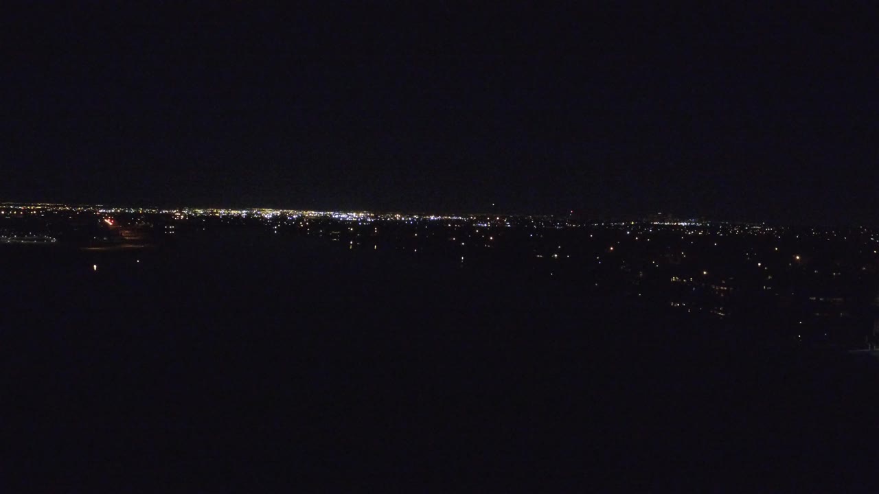 Dark aerial city lights under a black night sky.