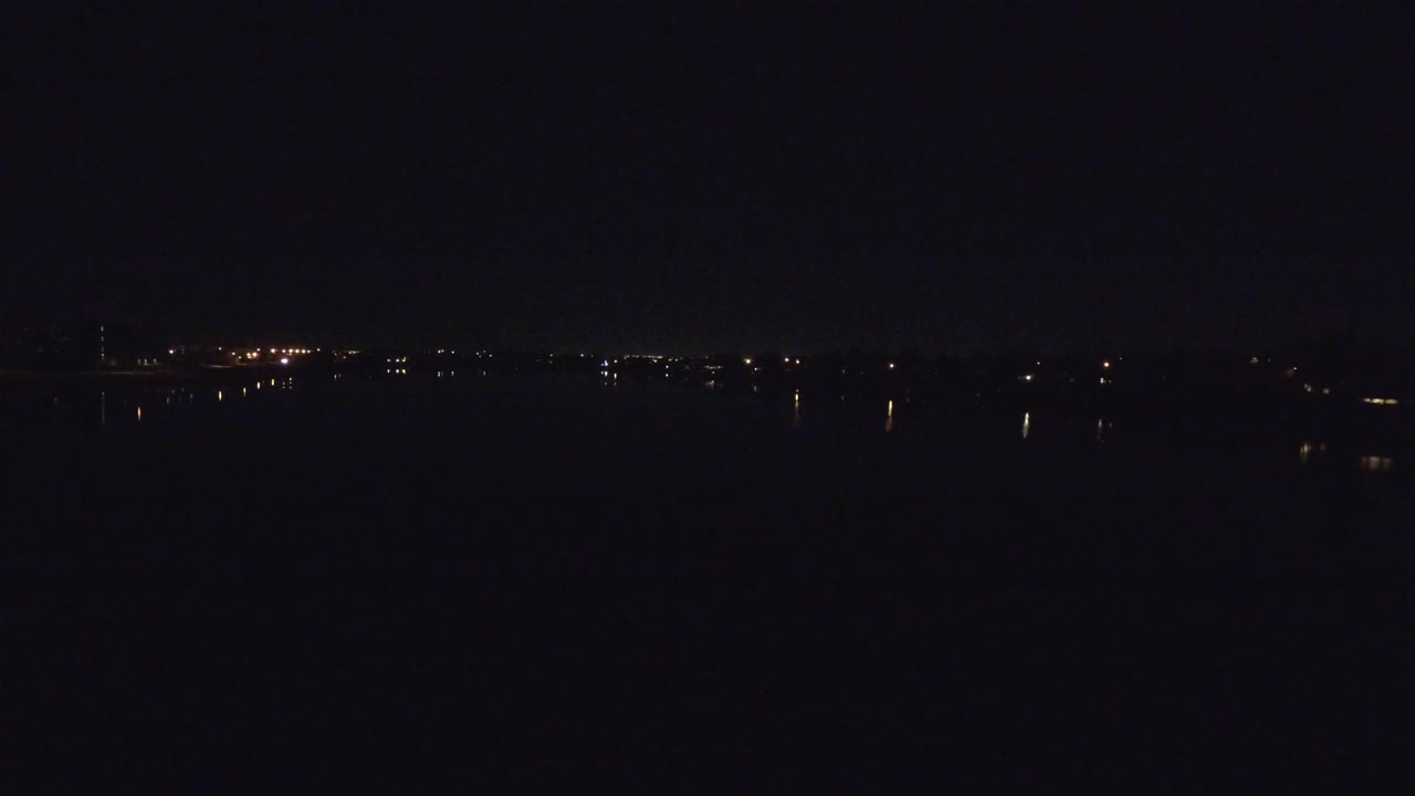 Distant city lights over a nearly black lake