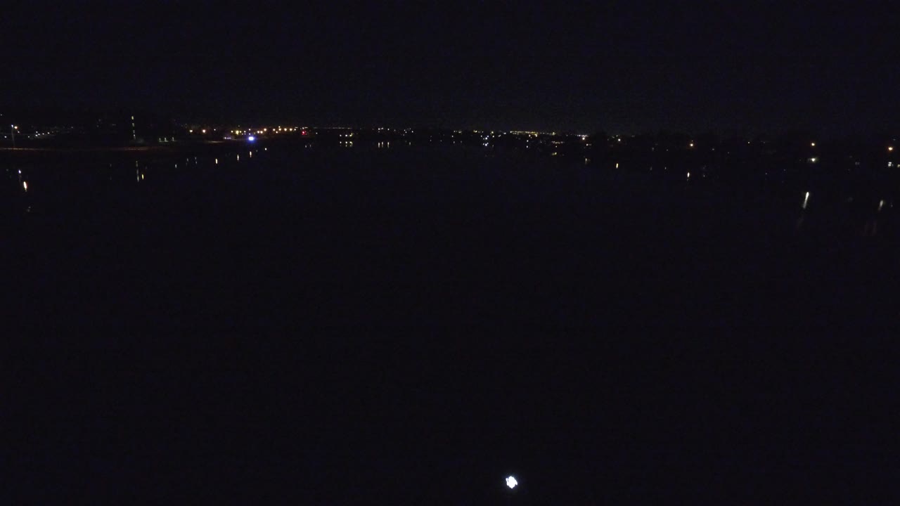Dark night skyline with scattered distant city lights.