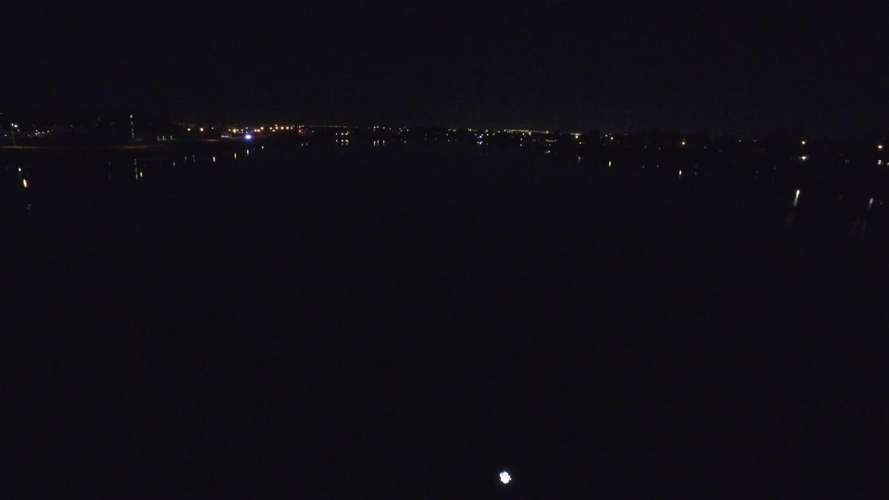Denver city lights sit low on the horizon in a nearly black frame, with no visible people or readable signs.