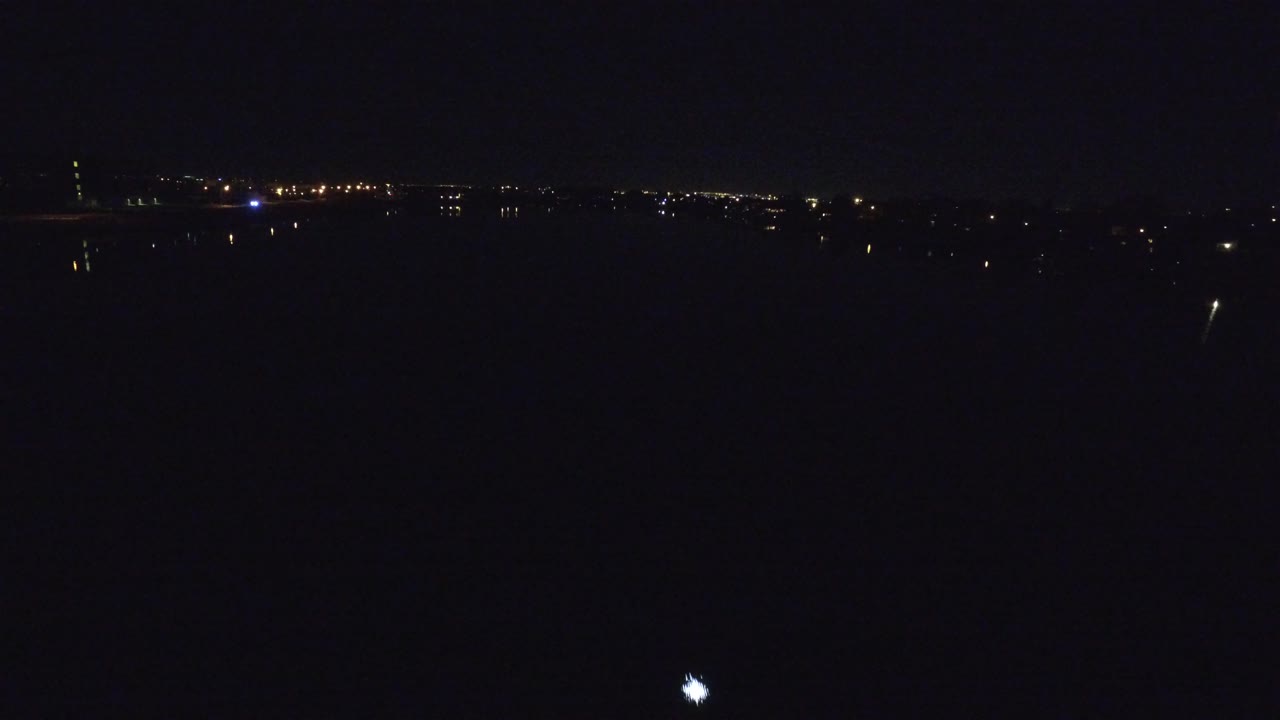 Distant city lights across a dark nighttime horizon.