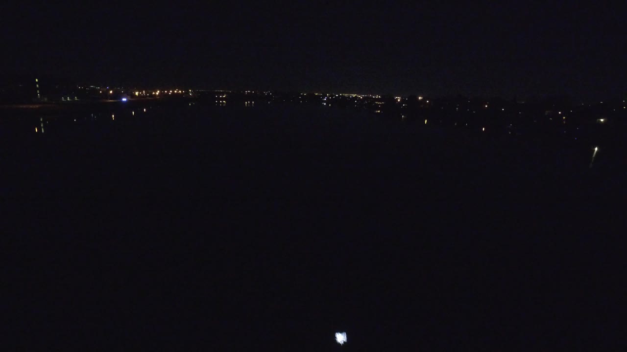 A dark foreground fills most of the frame while Denver's distant lights remain small along the upper horizon, with no visible people.