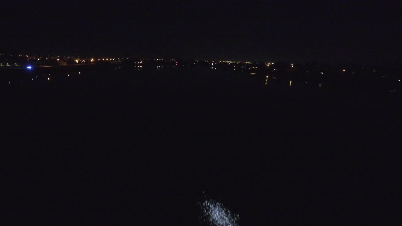 A Denver airport night view with amber horizon lights and a pale illuminated patch on the dark tarmac, with no visible people.