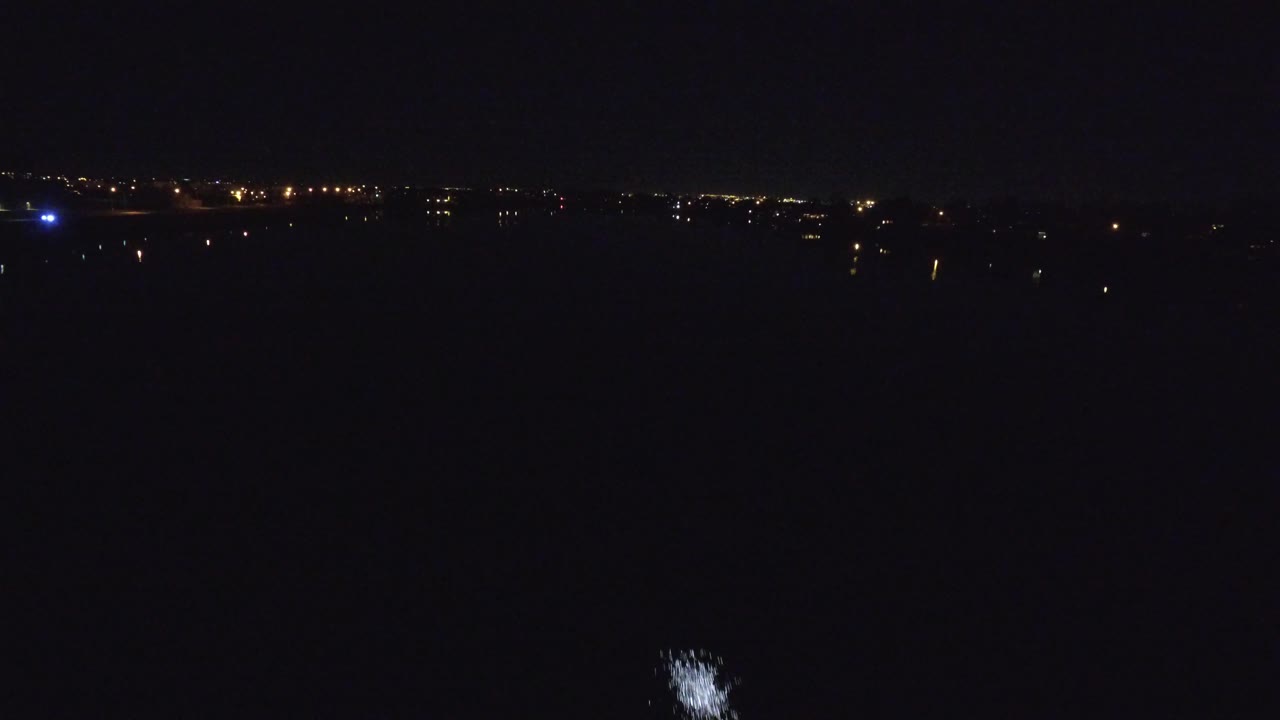 Sparse city and runway lights over a mostly black foreground.
