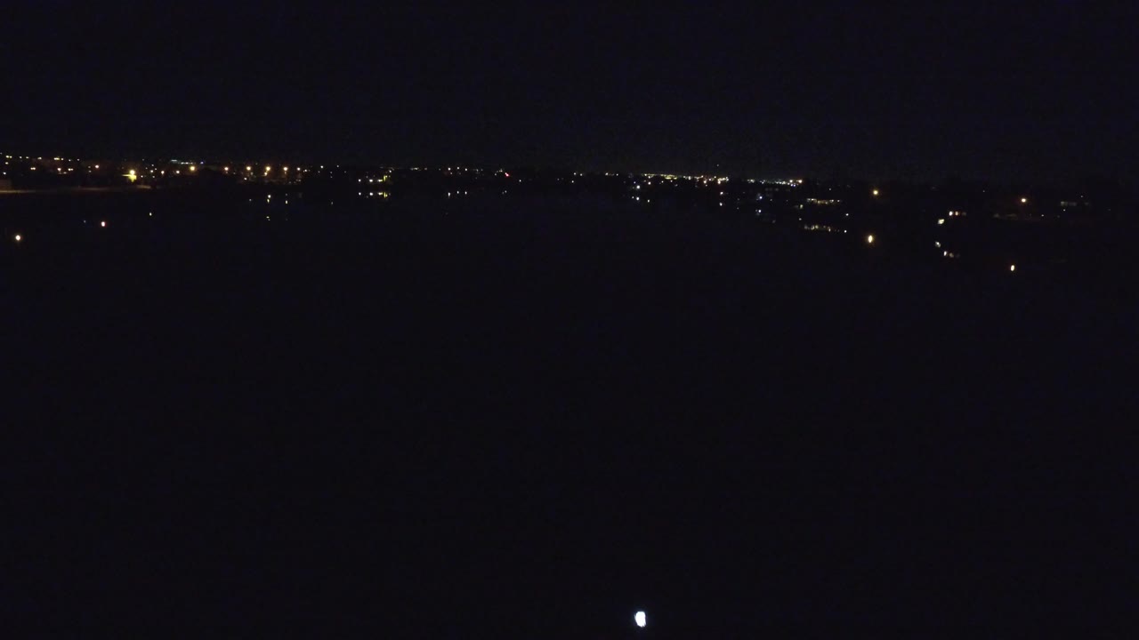 Denver, Colorado night frame with distant light clusters, a small bright point in the dark mid-frame, and no visible people.