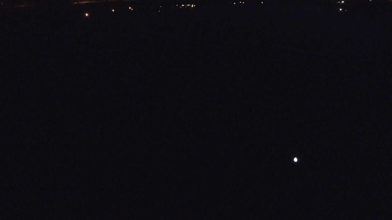Very dark night scene with tiny distant lights.