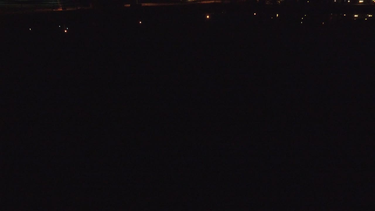 Denver, Colorado frame showing heavy darkness with several small distant lights across the top band and no visible people.