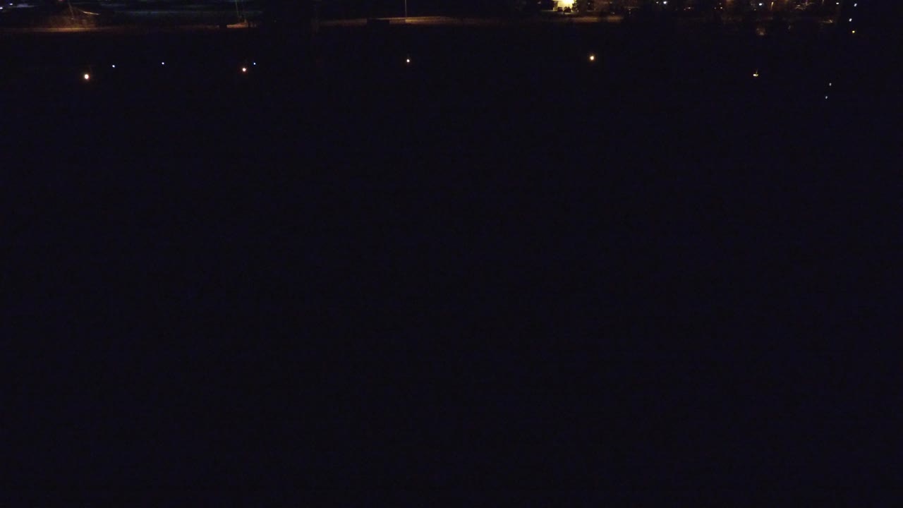 Dark waterfront at night with distant lights