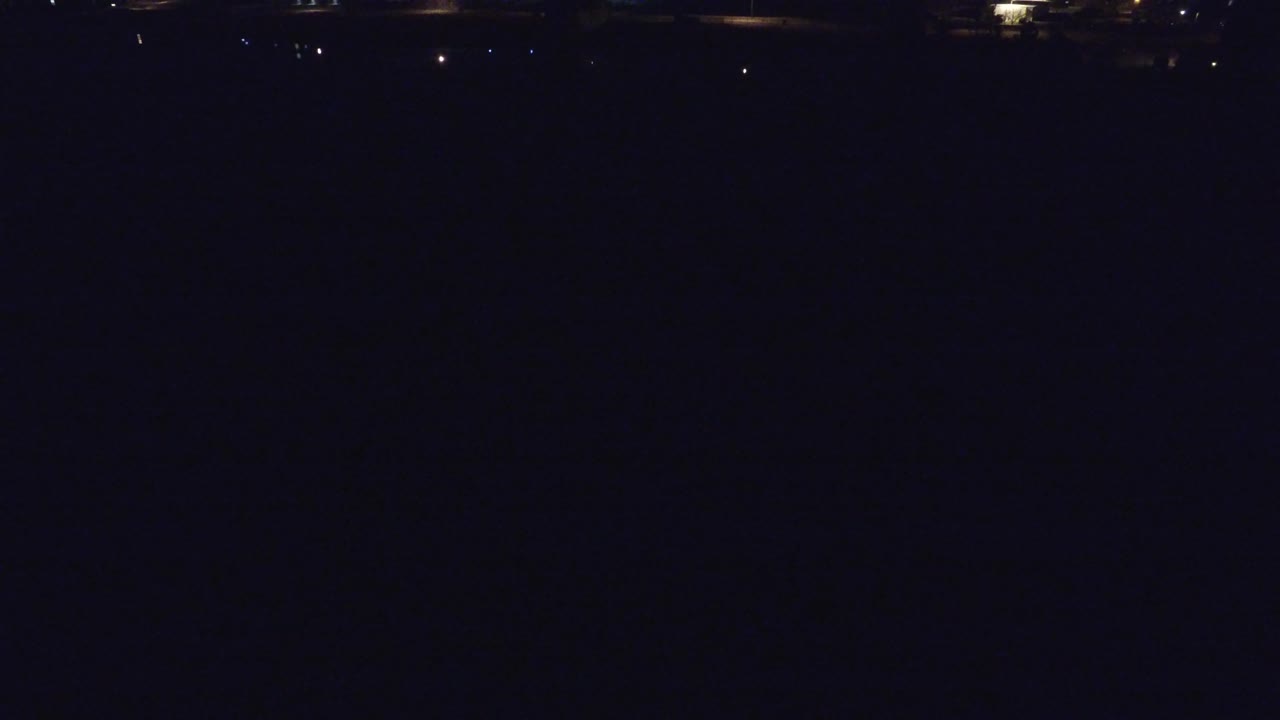 Low-light bridge scene with a few isolated lights in the distance.