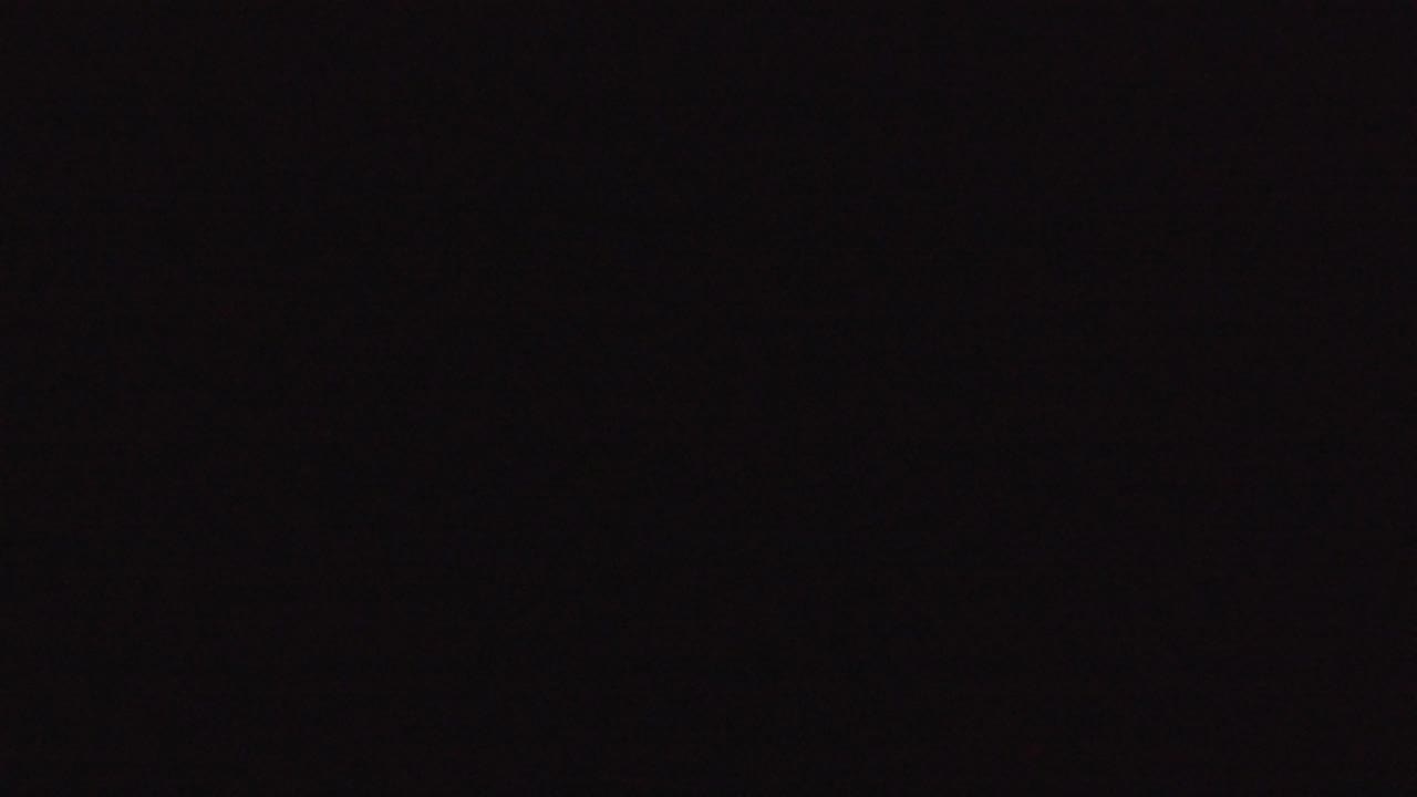 Nearly black opening frame from the Denver 2016 clip with faint reddish shadow texture and no visible people.