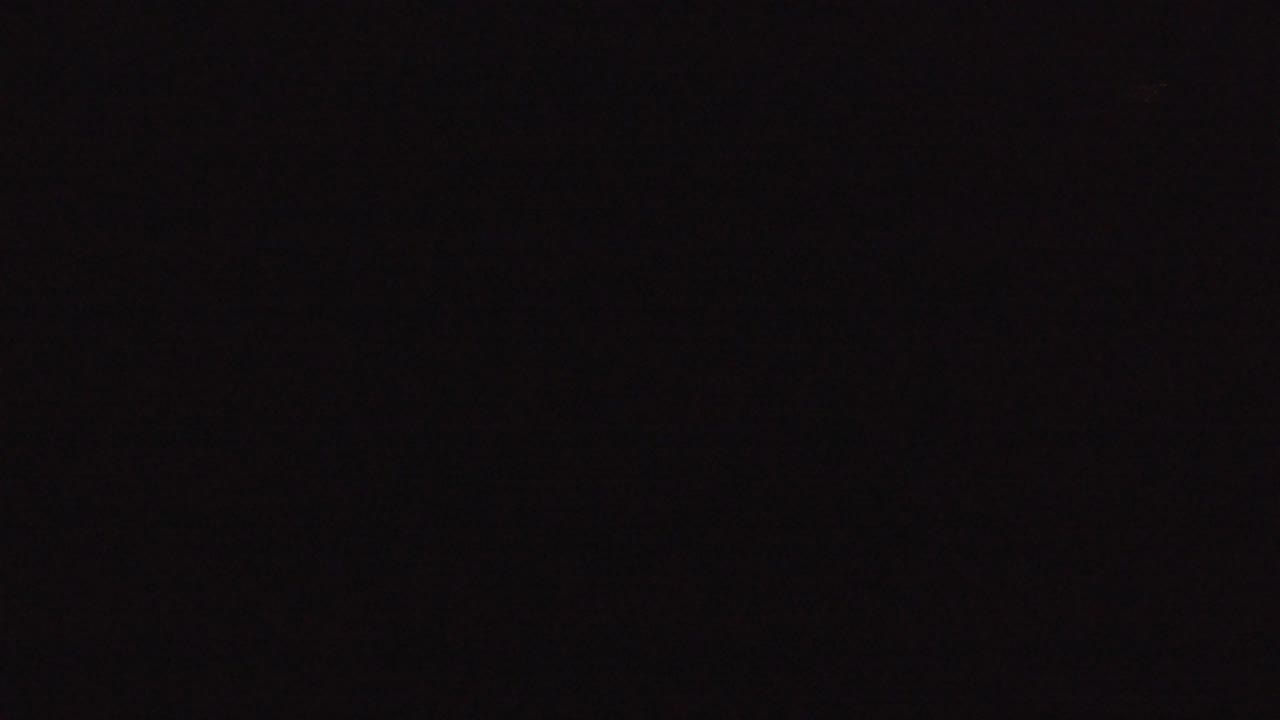 Very dark opening frame from the Denver, Colorado clip, with only a few faint warm points visible and no visible people confirmed.