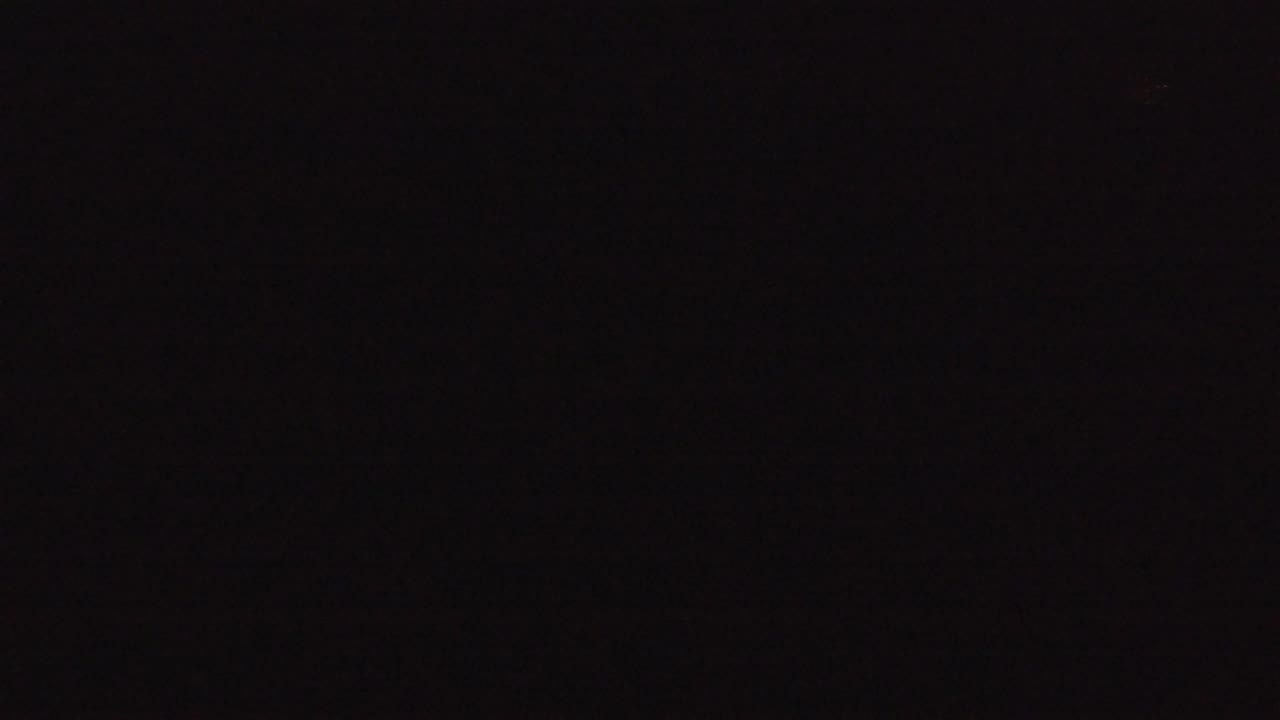 Near-black second frame from the Denver, Colorado footage, showing tiny dim highlights against an otherwise dark image and no visible people confirmed.
