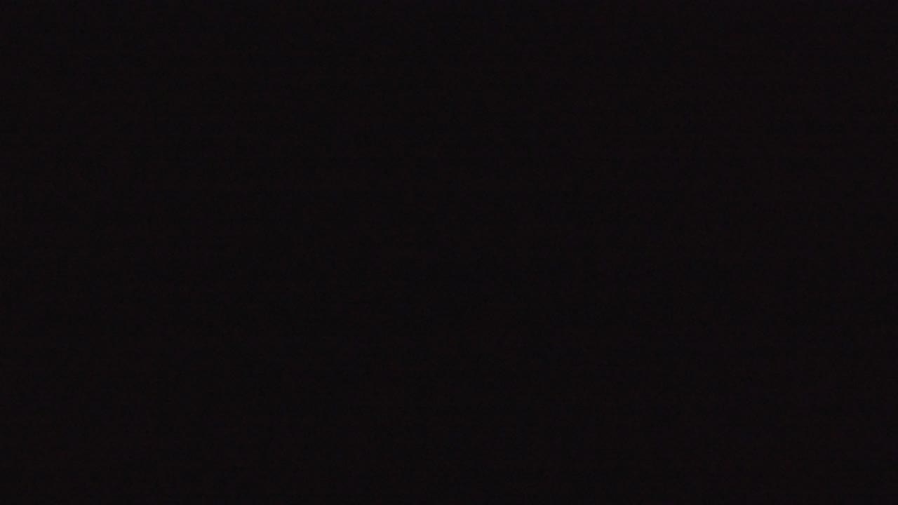 The opening frame from the Denver 2016 clip is nearly black with subtle red-gray noise and no visible people.