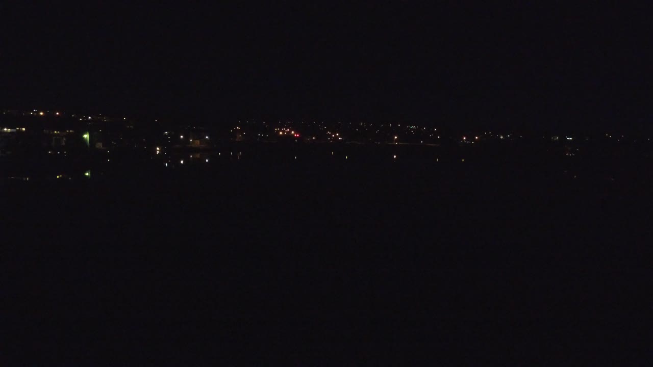 Denver, Colorado night skyline from an aerial position, with small white and amber lights stretching across the distance and no visible people.