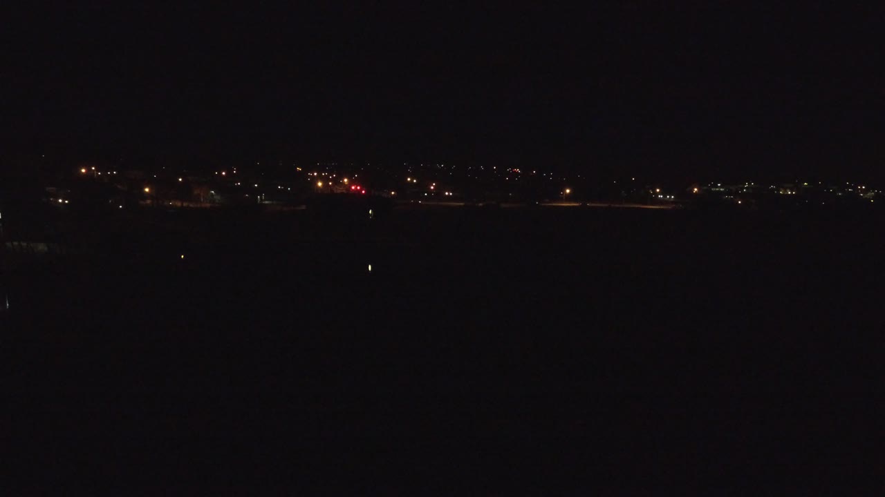 Denver night skyline area seen as scattered lights above a nearly black foreground, with no visible people.