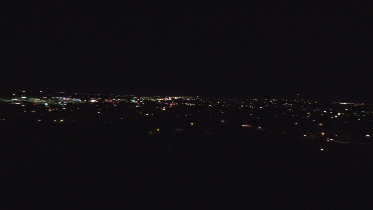 Distant city lights under a dark night sky.