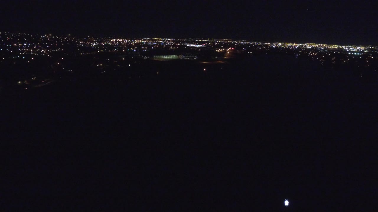 Distant city lights under a dark night sky.