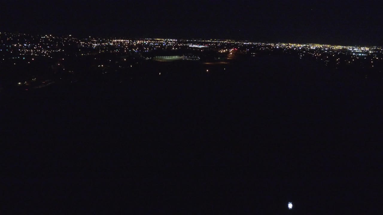 Denver city lights stretch across the upper portion of the frame while the lower half remains nearly black, with no visible people.