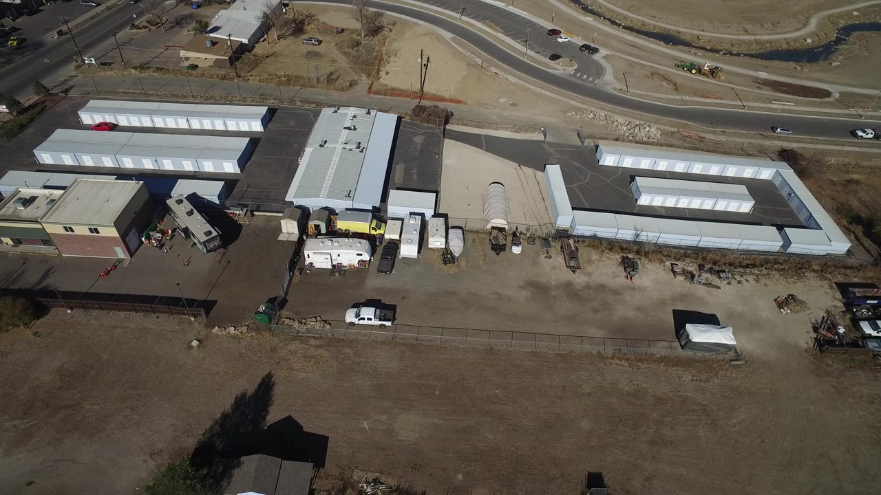 Overhead view of storage units beside roads and dry grass.