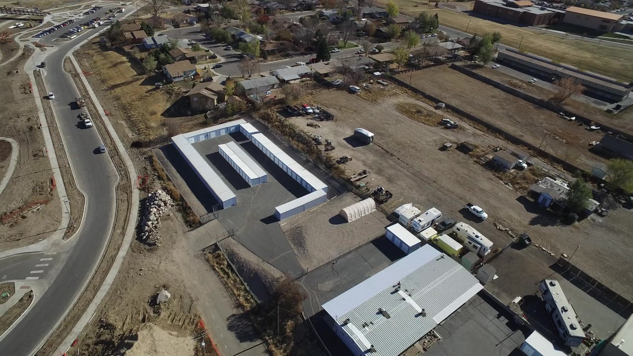 Aerial view of industrial roofs, surrounding lots, a road intersection, and homes.