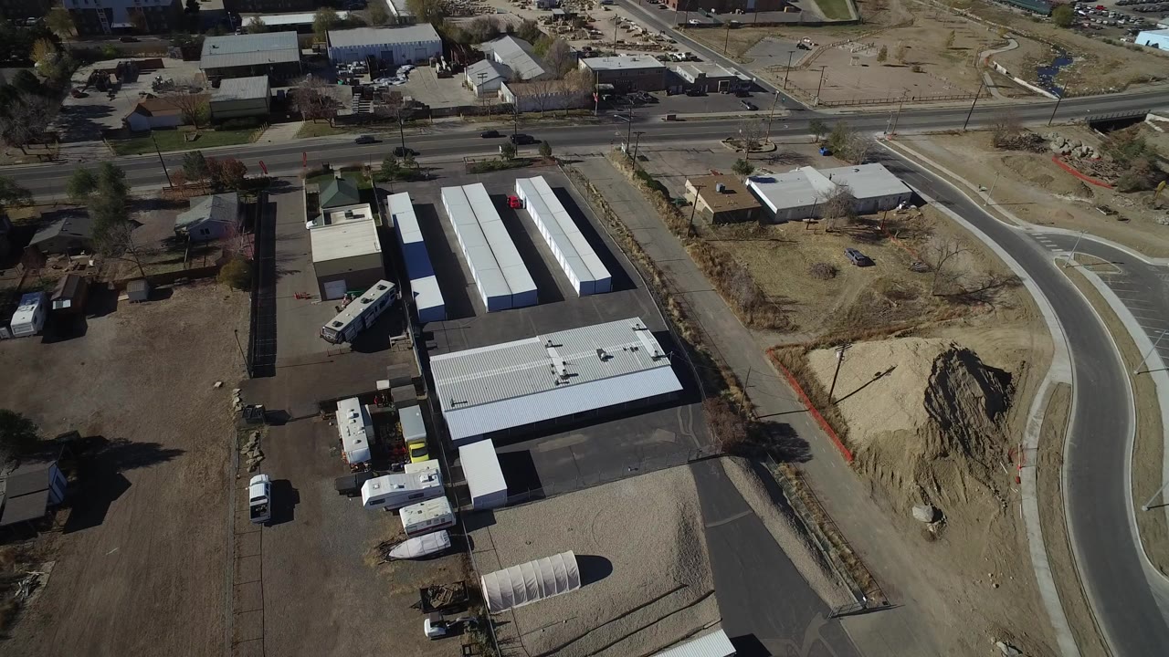 Aerial view of warehouses beside a curving industrial road.