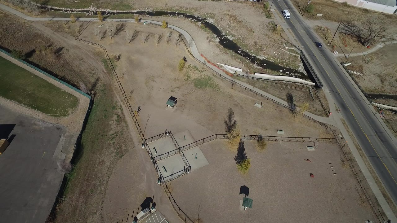Aerial view of a road beside a dry park and creek.