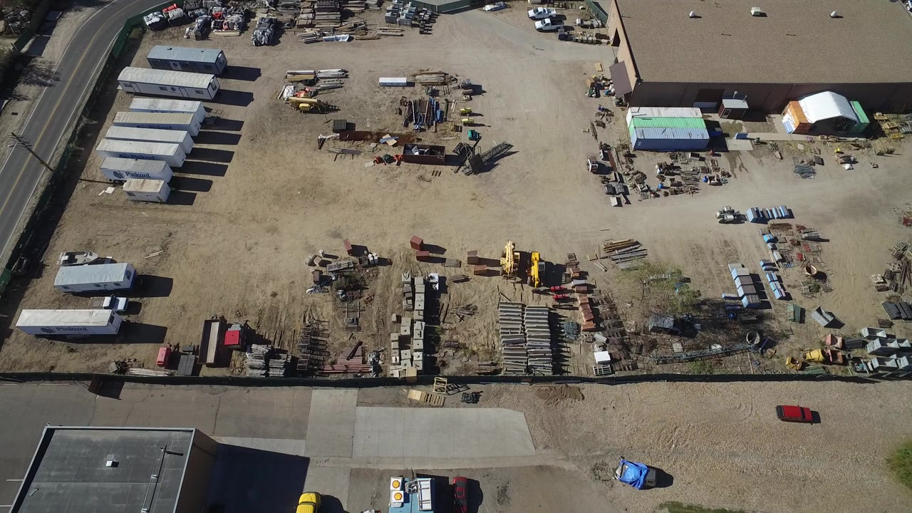 Top-down Westminster, Colorado frame showing rows of stored materials, several trailers, a large flat-roof building, parked trucks, and no visible people.