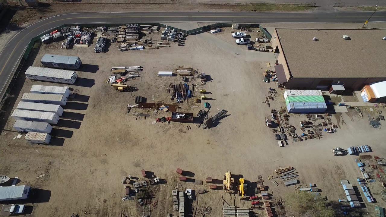 Overhead view of an industrial storage yard beside a road.