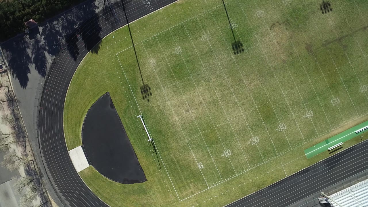 Overhead view of a football field inside a running track.