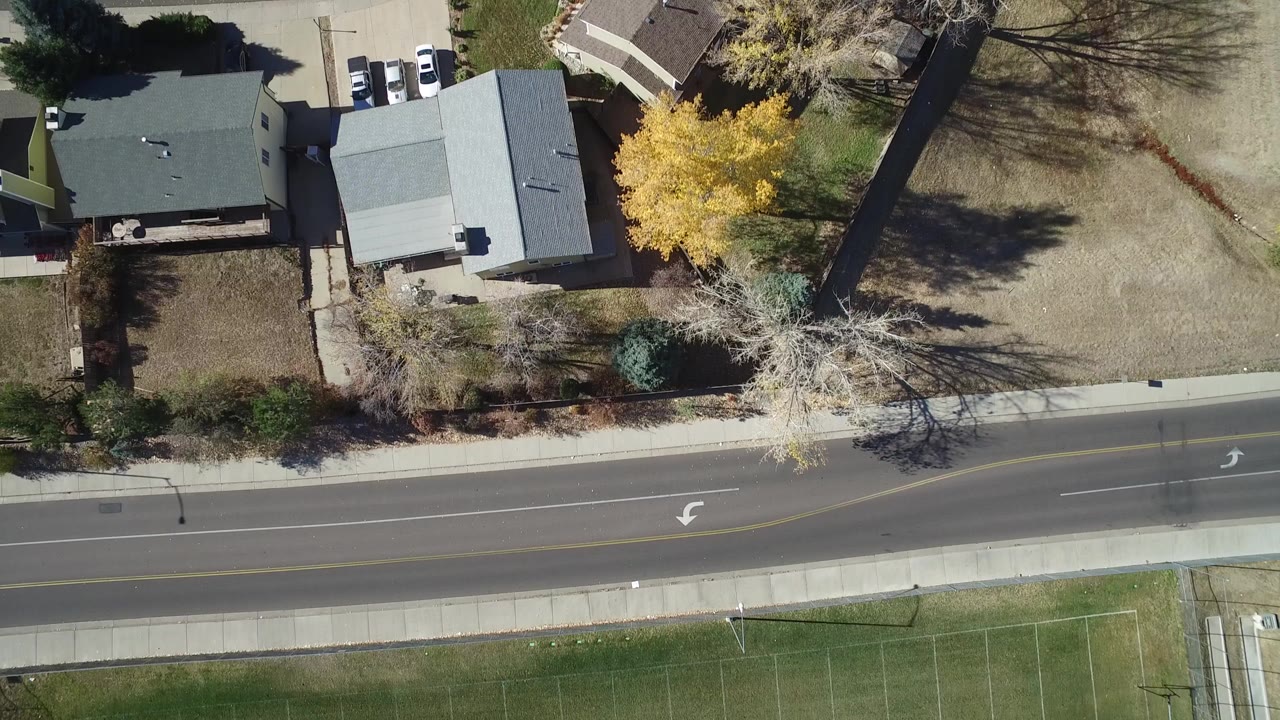 Overhead view of suburban houses beside a two-lane road
