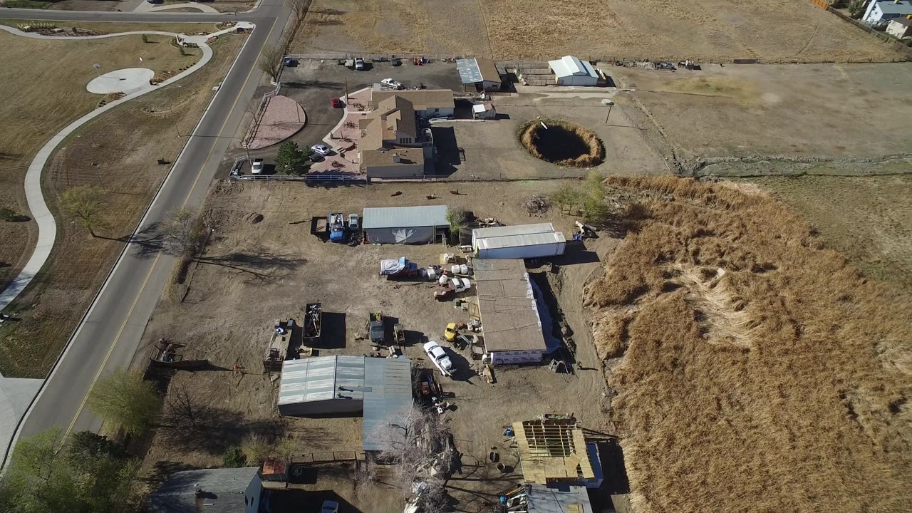 Drone view of a work site next to a road and dry open ground.
