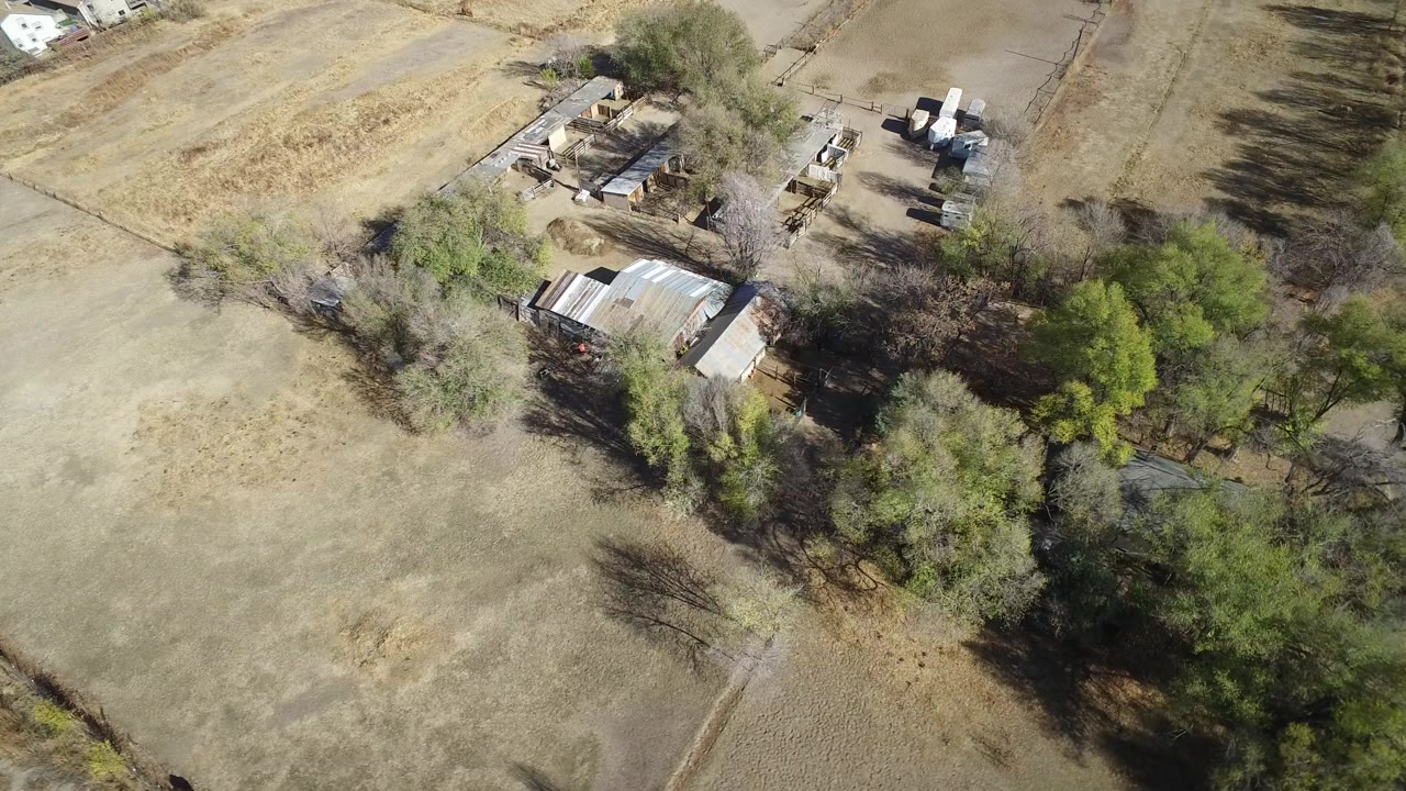 Aerial frame in Hidden Lake, Colorado with the building cluster slightly more centered among tan fields, green trees, and no visible people.