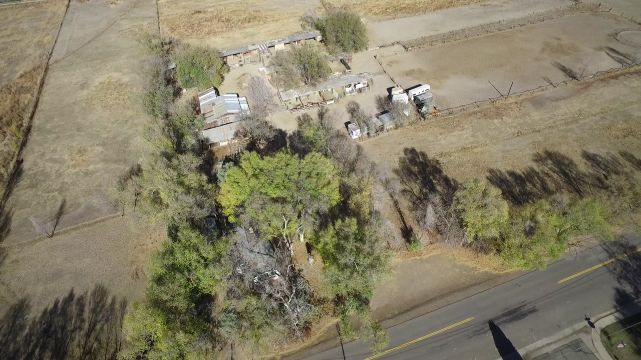 Overhead view of a rural property beside a two-lane road.