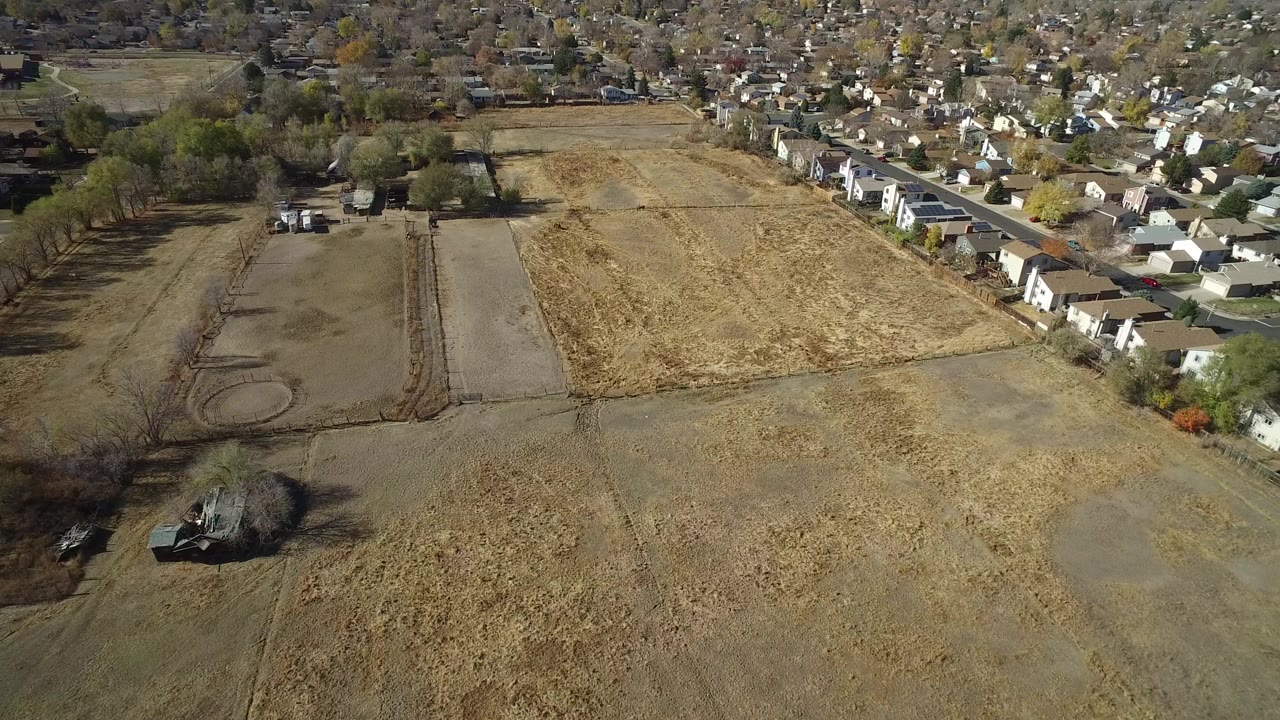 Aerial view of dry cleared land beside rows of houses.