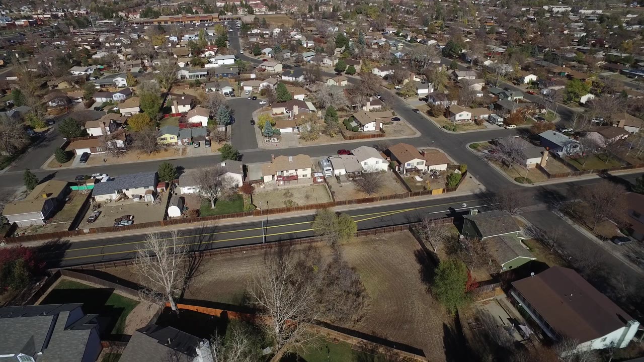 Aerial view in Hidden Lake, Colorado showing detached homes, a cul-de-sac, backyard fencing, a wide road, winter-brown lawns, and no visible people.