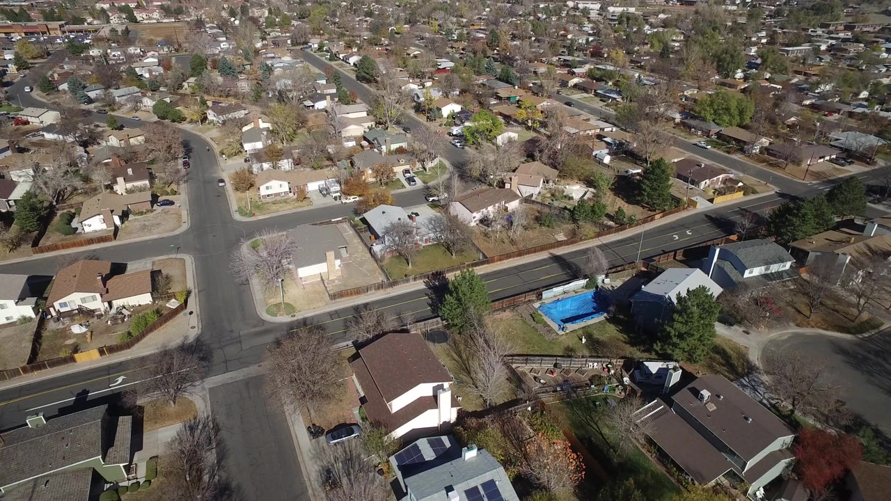 Aerial neighborhood view with curving street and backyard pool