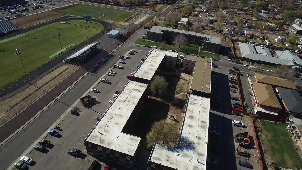 Aerial view of an office building beside parking lots and sports fields.