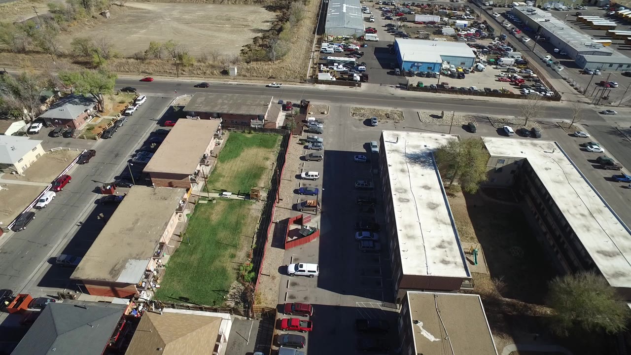 Aerial view of parking lots, roads, buildings, and parked cars.