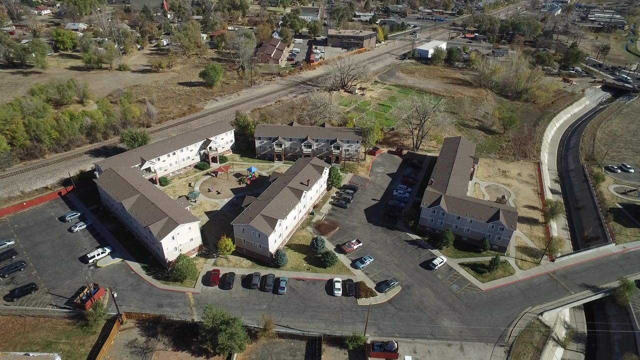Aerial view of low-rise buildings around a parking lot and courtyard