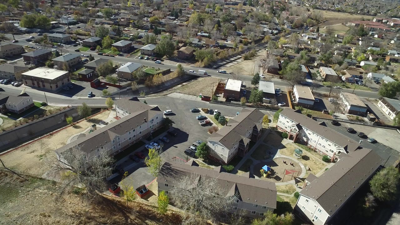 High aerial view of apartment buildings, streets, houses, and parking areas.