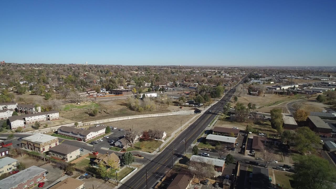 Aerial view of a suburban road through low commercial buildings and parking lots.