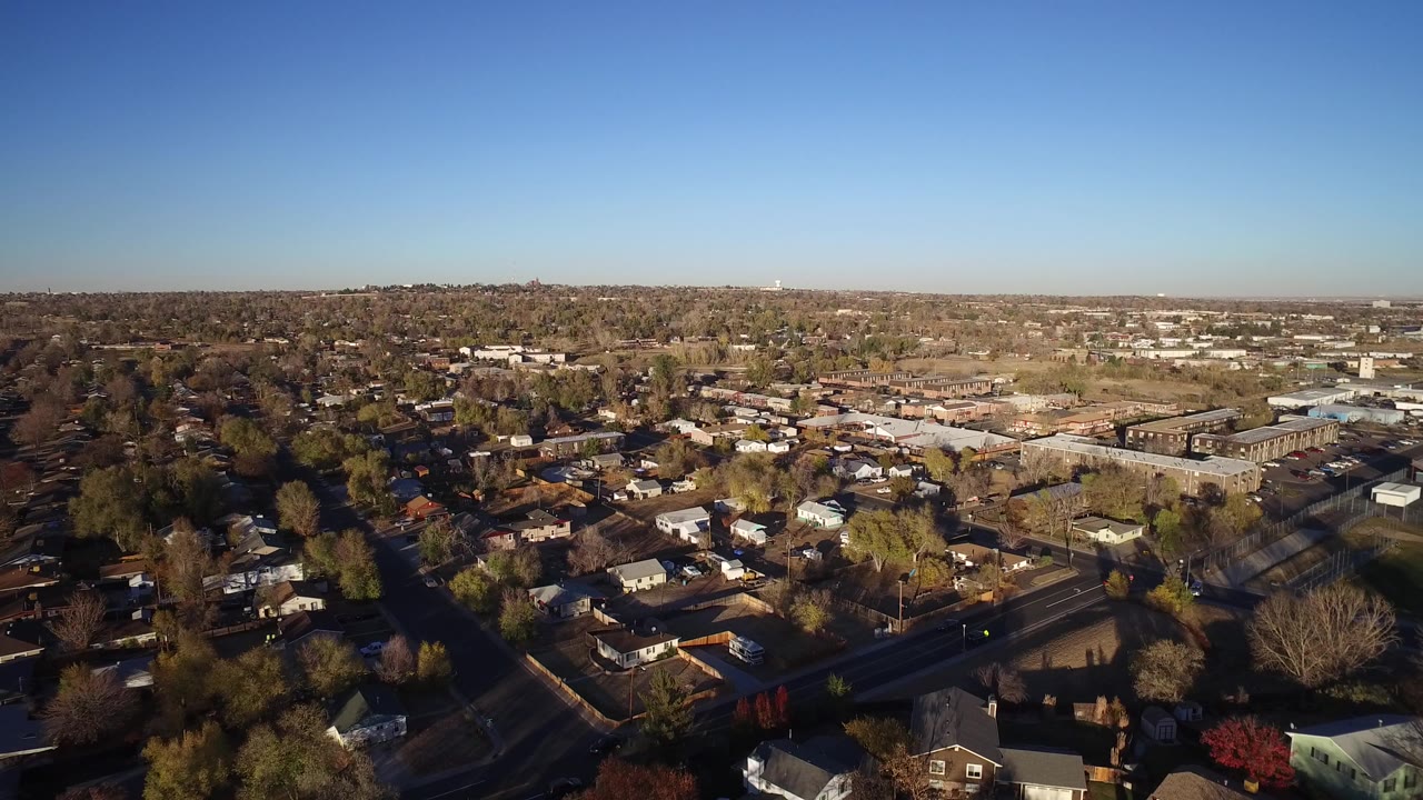 Wide aerial view over Westminster, Colorado homes and streets, with a broad blue sky and no visible people at the start of the clip.