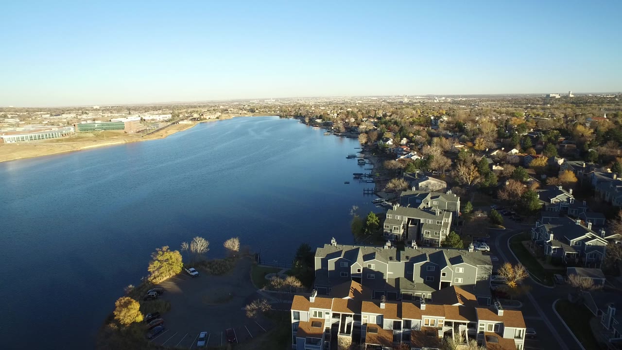 Aerial view of homes beside a wide waterway.